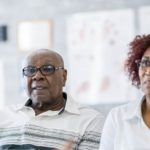 A senior couple listening intently to their female doctor.