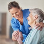 Caregiver holding hand of elderly patient
