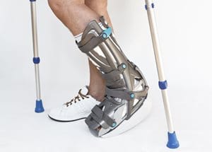 Patient on crutches with boot for offloading